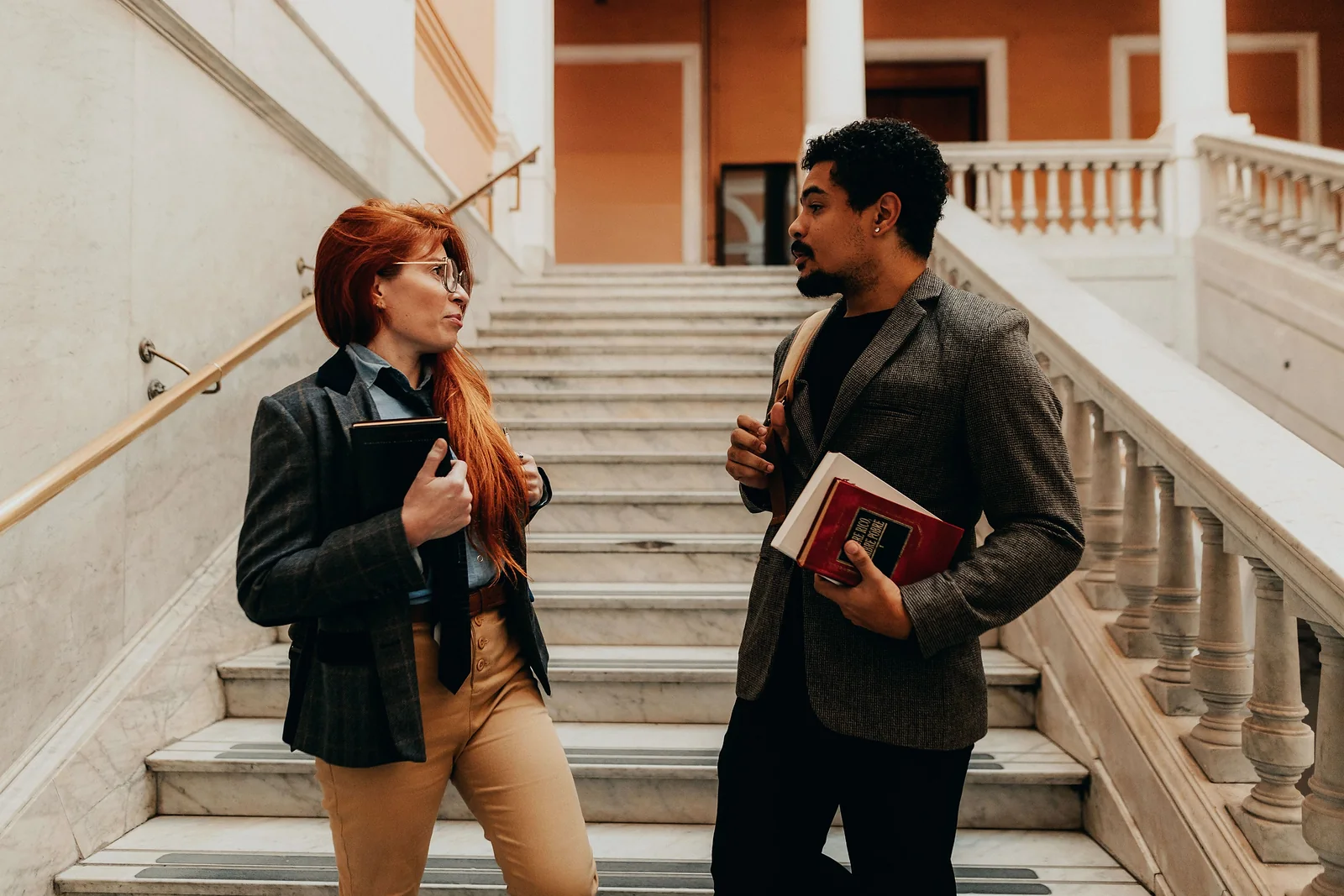 Deux étudiants discutent dans un grand escalier