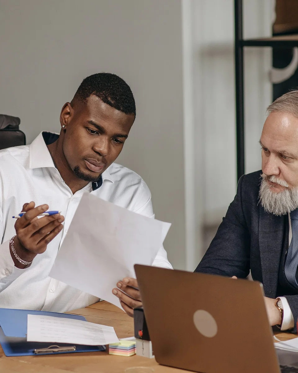 Un jeune commercial présente une proposition à un client autour d'un bureau
