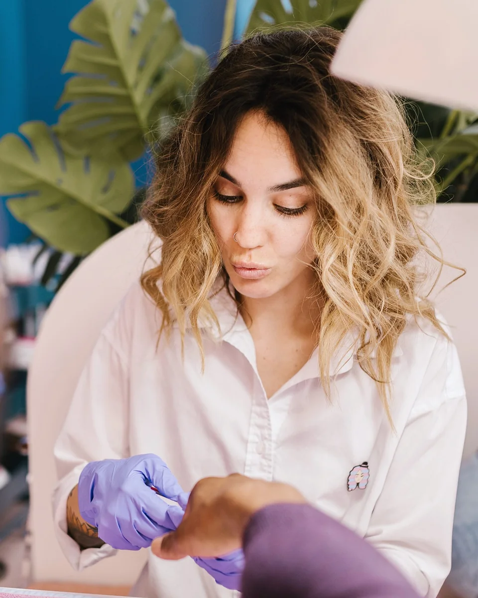 Une prothésiste ongulaire réalise une pose en salon