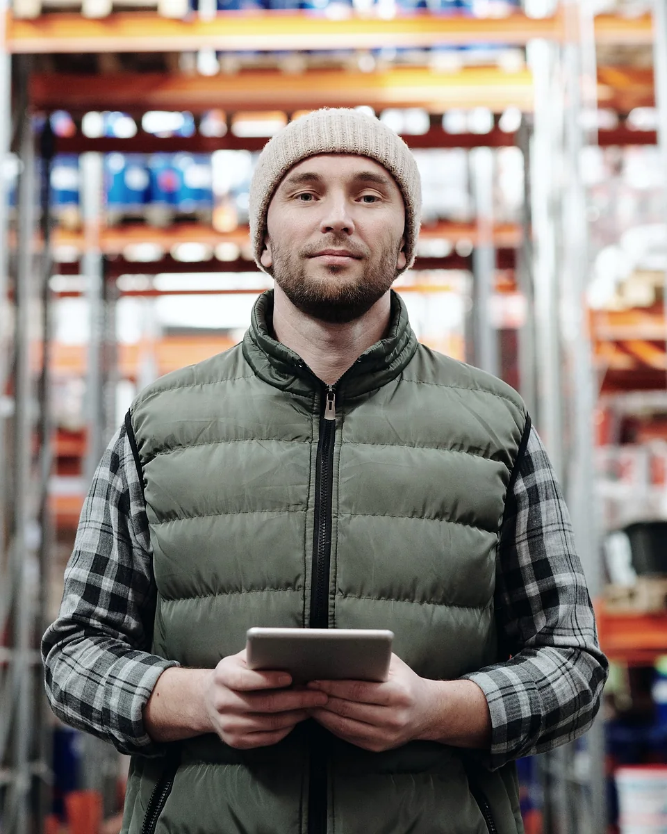 Un gestionnaire logistique consulte sa tablette dans un entrepôt